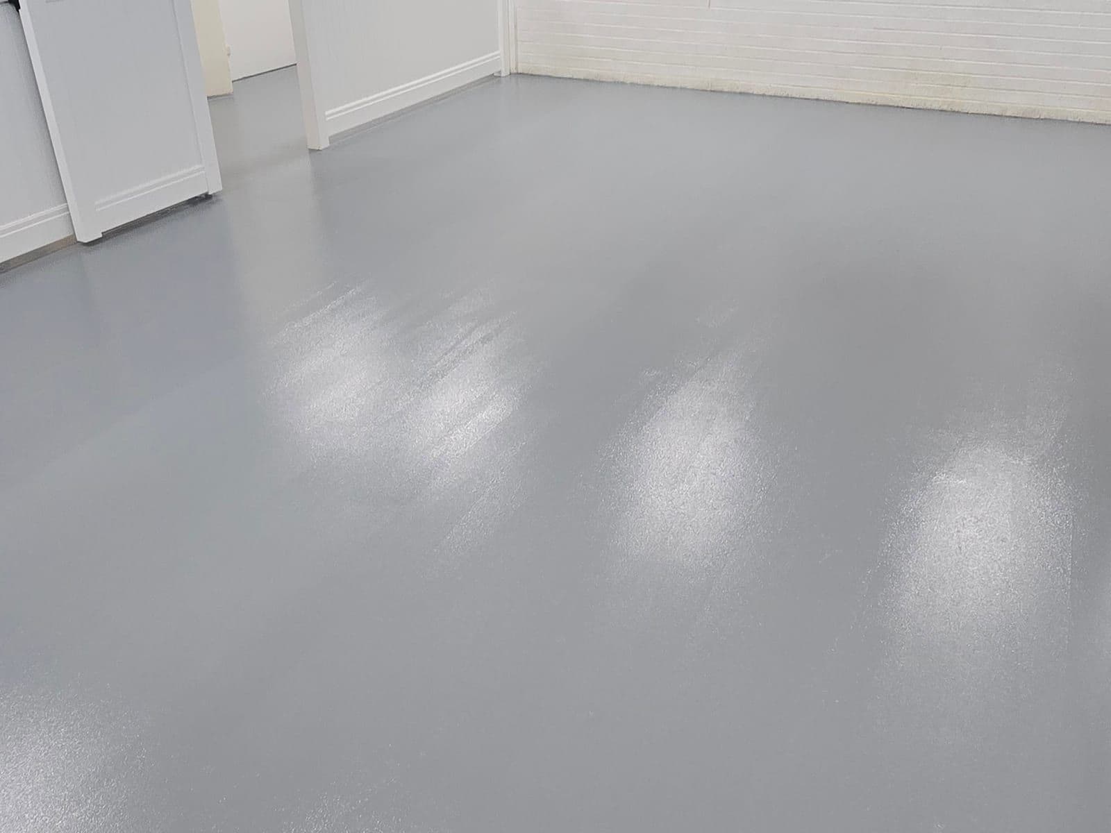 Epoxy floor finish in a large workshop with classic cars