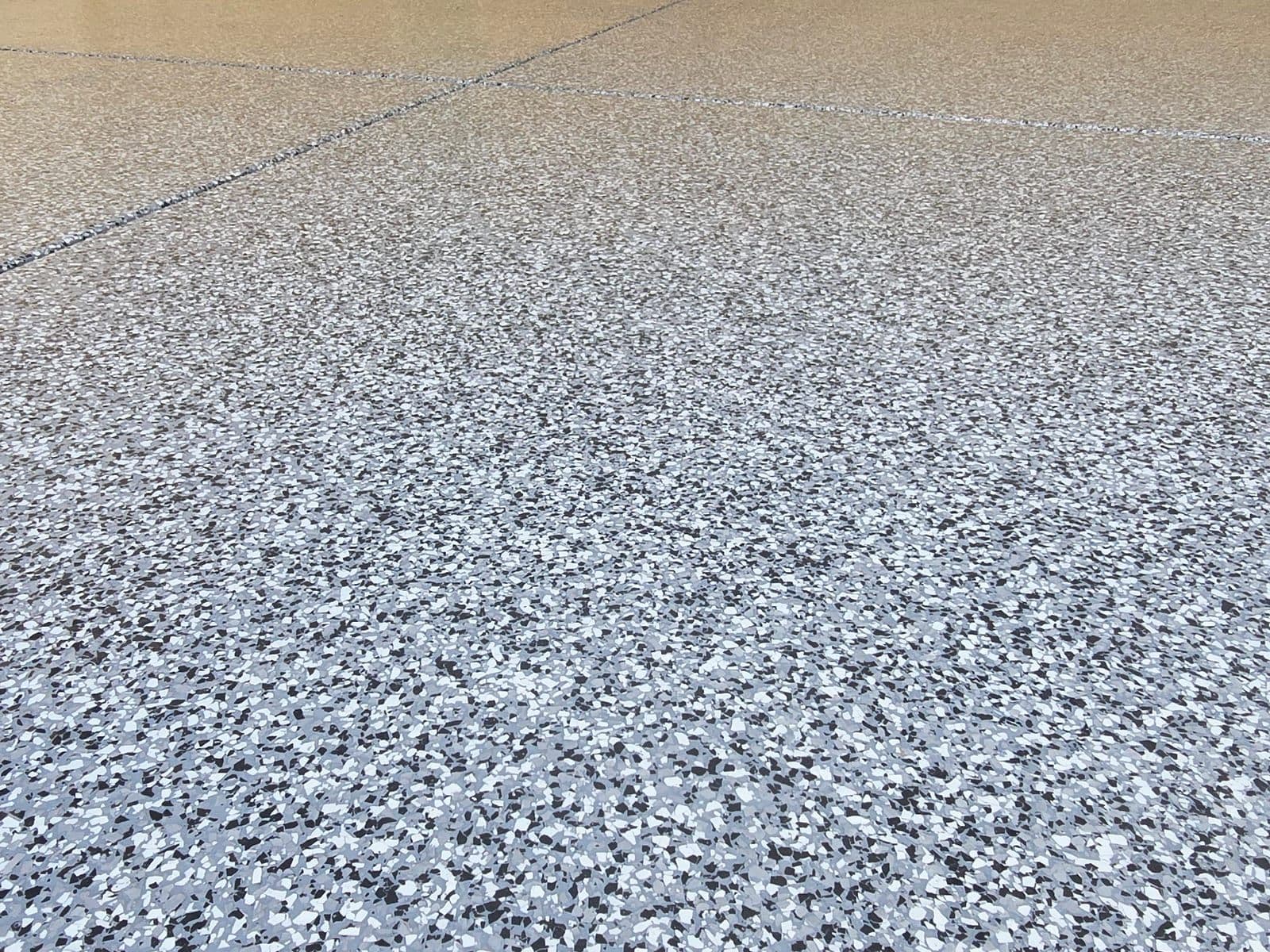 Alfresco flake epoxy floor bordered by paving
