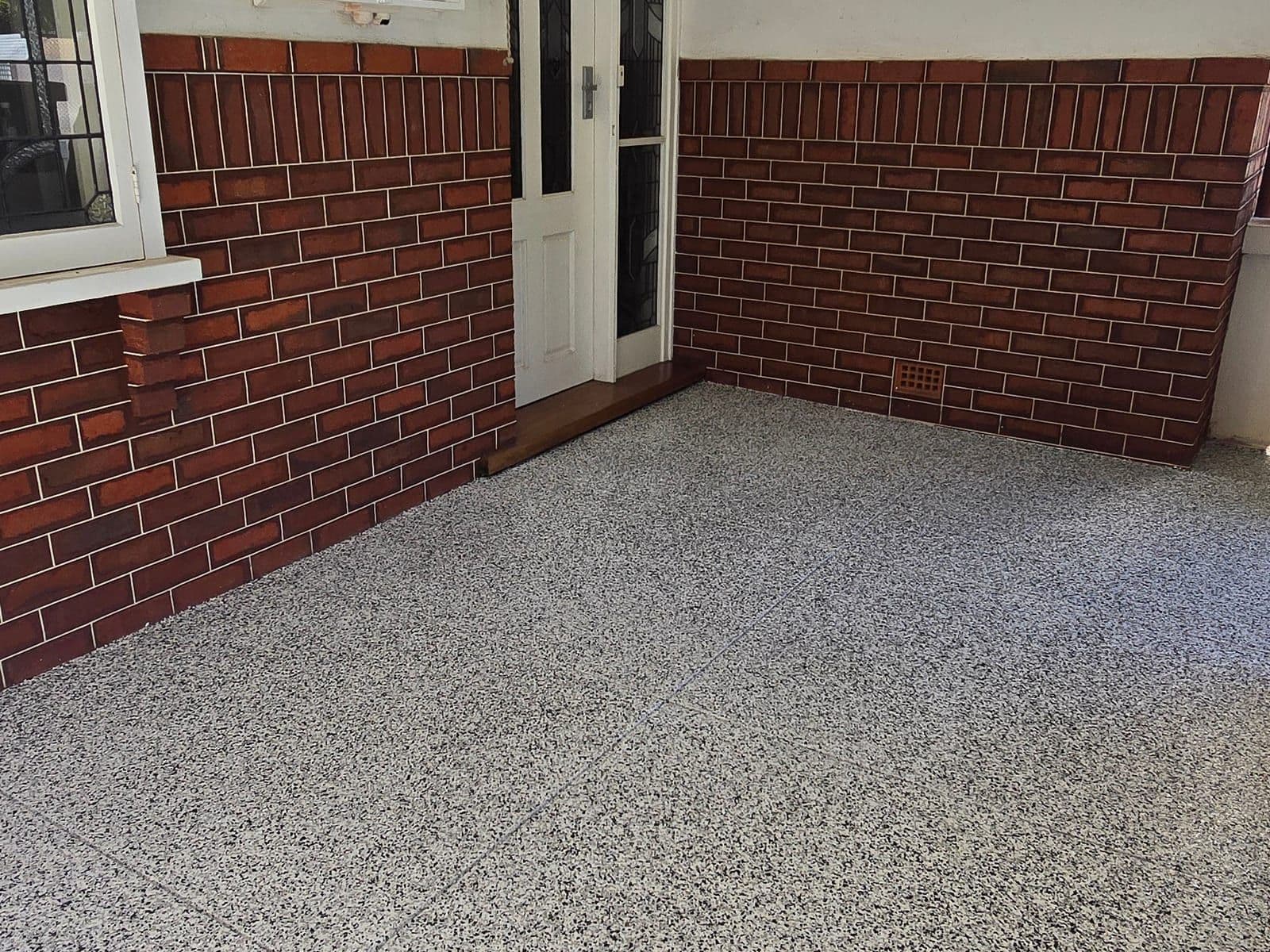 Flake epoxy floor beside a brick paved driveway